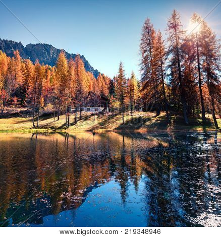 Fantastic colors view of Scin lake with yellow larch trees. Colorful sunny scene in Dolomite Alps Cortina d'Ampezzo location Italy Europe. Artistic style post processed photo.
