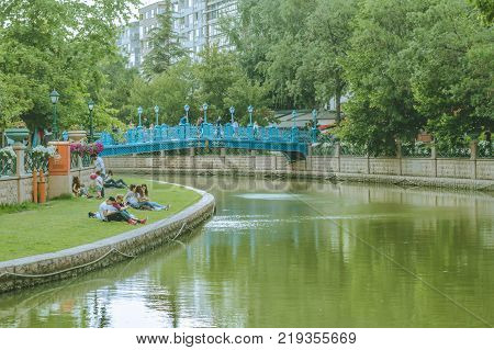 Eskisehir Turkey - June 14 2017: Youth enjoying the sunny summer day on grass near Porsuk River Eskisehir. Eskisehir is a modern city in center of Anatolia.