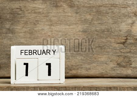 White block calendar present date 11 and month February on wood background