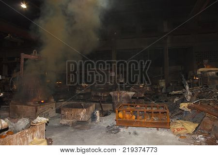 sparks fly as scrap steel melts down in an induction furnace at a small old chinese foundry