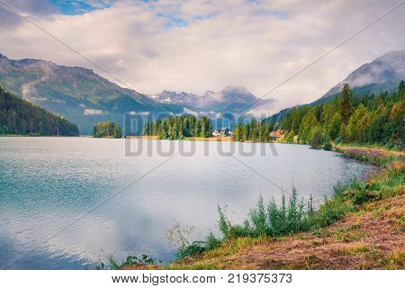 Sunny summer landscape of Silvaplana lake. Colorful morning view of Segl village Maloja pass Upper Engadine in the Swiss canton of the Grisons Switzerland Europe. Artistic style post processed photo.