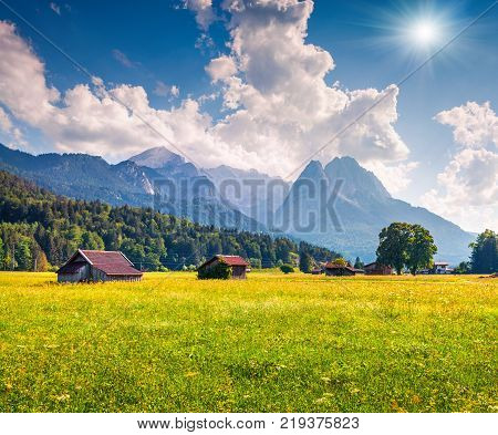 Sunny summer view of Garmisch-Partenkirchen mountain ski resort. Coloful outdoor scene with highest peak of the Wetterstein Mountains Bavaria Germany Europe. Artistic style post processed photo.