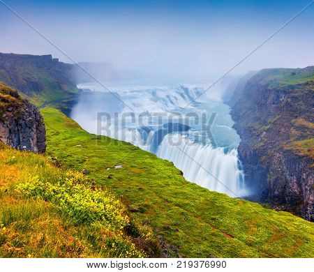 Huge waterfall Gullfoss in the morning mist. Colorful summer scene on Hvita river in southwest Iceland Europe. Artistic style post processed photo.