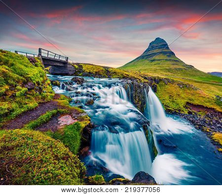 Summer sunset on famous Kirkjufellsfoss Waterfall and Kirkjufell mountain. Colorful evening scene on Snaefellsnes peninsula Iceland Europe. Artistic style post processed photo.