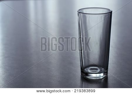 empty glass tumbler standing on gray table