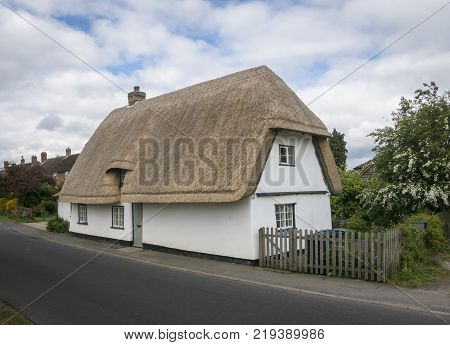 Street view of an old thatched cottage in the pretty village of Foxton Cambridgeshire England UK