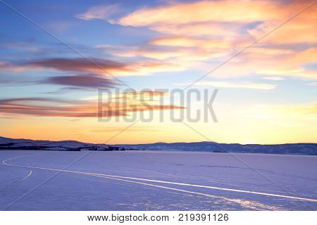 Baikal Lake. Ice Winter Road Near Olkhon Island At Sunset. Winter Travel On The Frozen Lake