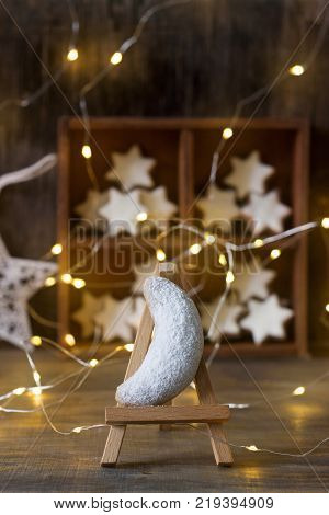 Vanilla crescents and cinnamon stars in the background with a garland, a wooden box and a star. Selective focus.