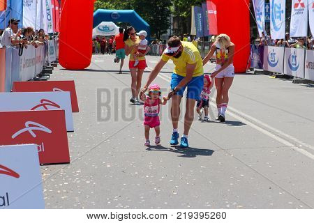 ODESSA UKRAINE - 25 JUN 2017: Parents and children at marathon. Happy kid runners at finish line at summer maraton.