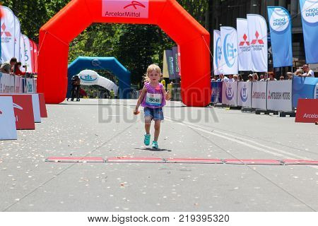 ODESSA UKRAINE - 25 JUN 2017: Beautiful little girl running children marathon. Femle kid runner at summer marathon.