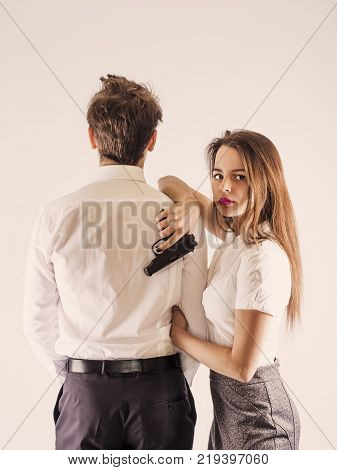 A cute guy and a girl are standing with a gun. Secret Service. White background.