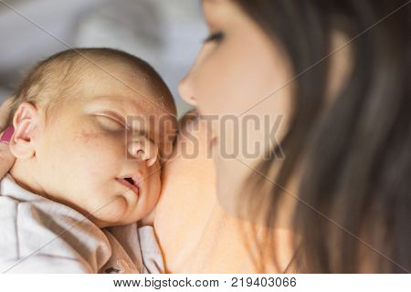 a young mother enjoys the first days of motherhood with her child holding it in her arms