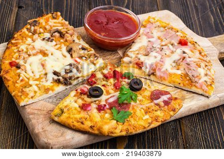 Three pieces of different pizzas on a wooden. Studio Photo