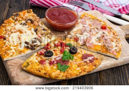 Three pieces of different pizzas on a wooden. Studio Photo