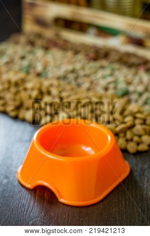 Small orange bowl for pet food and dry food as background