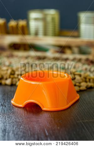 Small orange bowl for pet food and dry food as background