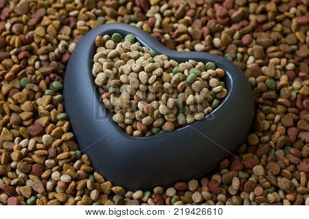 Heart pet bowl filled by dry pet food