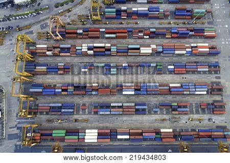 Containers yard shot from drone in port congestion with ship vessels are loading and discharging operations of the transhipments in international port.