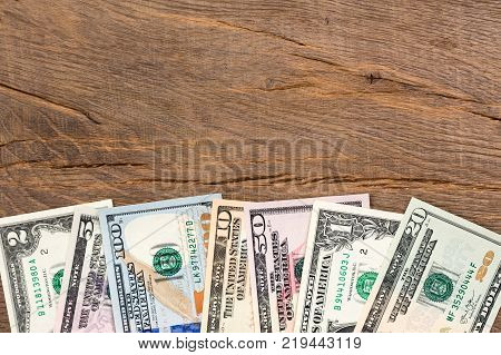 Cash dollar banknotes on wooden background. High resolution photo.