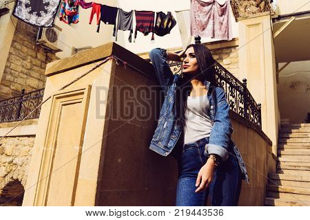 black haired charming girl posing against a colorful architecture of the city of Bacu