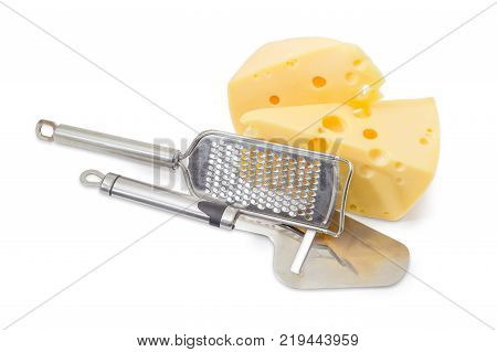 Cheese slicer and cheese grater against of the two pieces of Swiss-type cheese with holes on a white background
