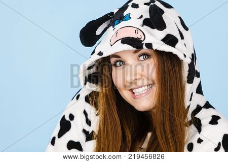 Happy teenage girl in funny nightclothes pajamas cartoon style smiling positive face expression studio shot on blue.