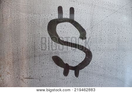 The dollar symbol on the misted sweaty glass. Abstract background image. US money concept