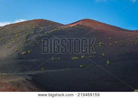 timanfaya national park, Lanzarote, Canary islands, Spain. Red mountains in the distance. Clear blue sky. Red Mountains in focus. Landscape.