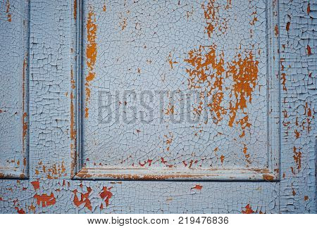 Wooden wall with blue paint is severely weathered and peeling. close up