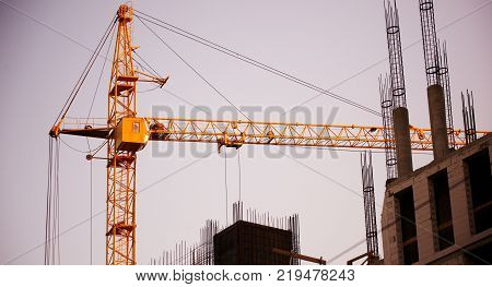 building of a skyscraper by cranes at sunset