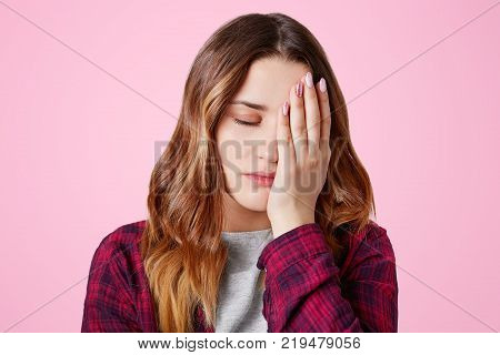 Headshot Of Unhappy Sorrorful Female Curves Lips, Looks Desperately At Camera, Being Upset To Hear B