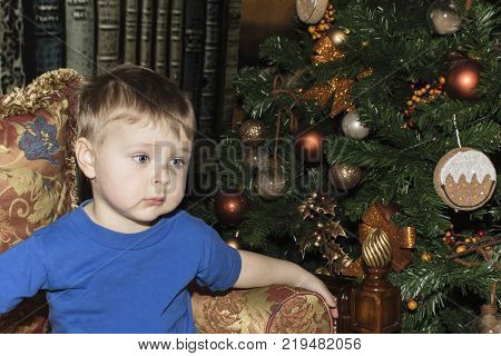 Sweet and serious baby is staring, waiting for Santa Claus