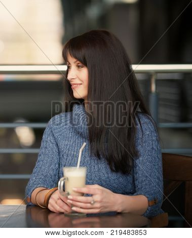 happy lonely woman drinking coffee in cafe