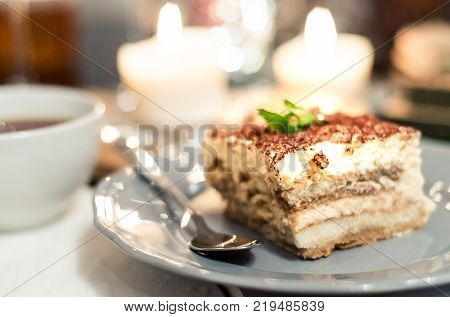 Tiramisu, traditional Italian dessert on a white plate