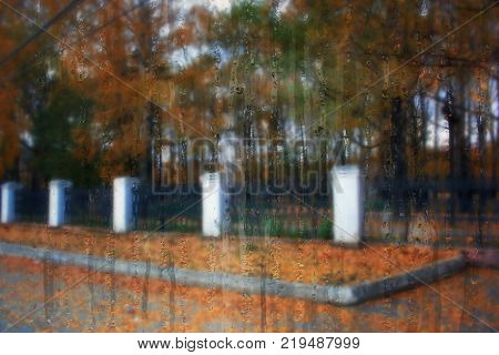 Autumn street on a rainy day view through wet glass
