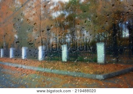 Autumn street on a rainy day view through wet glass
