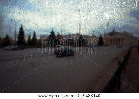 Autumn street on a rainy day view through wet glass