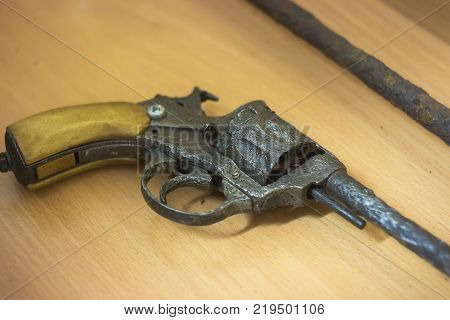 an old rusty revolver lying on the table