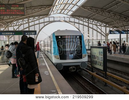 Wuhan Hubei China, 24 December 2017: Chinese people waiting metro on aerial line 1 in Wuhan China with train enering station
