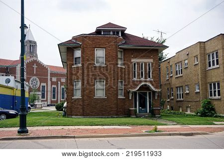 JOLIET, ILLINOIS / UNITED STATES - JULY 26, 2017: A brown brick two-story apartment building, in front the of Cathedral of Saint Raymond Nonnatus, on Plainfield Road in Joliet.