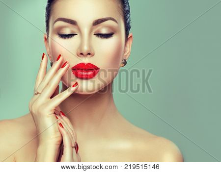 Beautiful Fashion woman model face portrait with red lipstick and red nails. Glamour girl with bright makeup. Beauty female. Perfect skin and make up and manicure. Red lips and nail polish