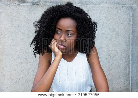 Sad african american with curly black hair looking around