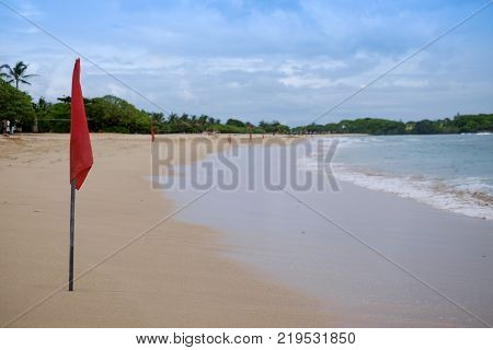 A red warning flag on the beach in the Nuca Dua Bali, Indonesia. Danger to swim in ocean