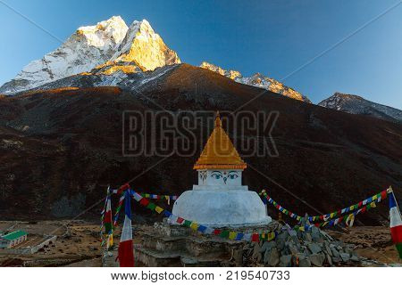 Buddhist stupa on mountain trekking path in Himalayas, Nepal.