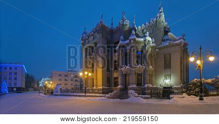 Illuminated House with Chimaeras or Horodecki House. Night scene. Building and street are powdered with snow.