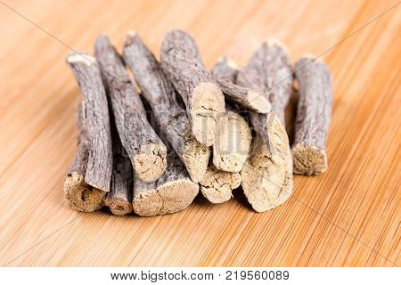 Pile Of Licorice Roots Isolated On A Wood Background