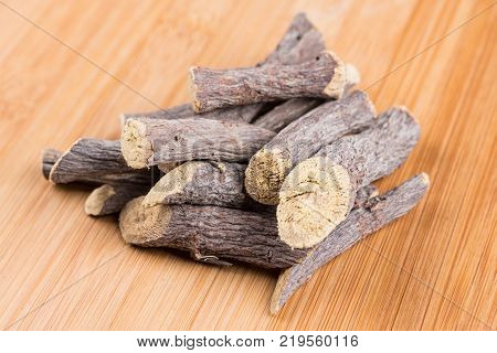Pile Of Licorice Roots Isolated On A Wood Background