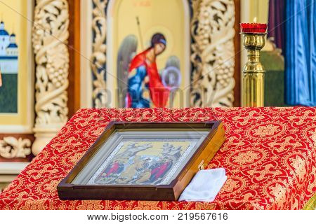 Belgorod Russia - May 20 2017: Burning candlestick with burning candle above pulpit with an icon for liturgy prayers and sermons in Orthodox cathedral's hall in honor of con of Mother of God "Softening of Evil Hearts".