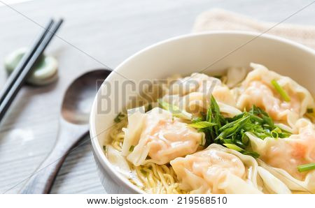 Shrimp wonton with braised pork in soup on wooden table - Asian food style Select focus image