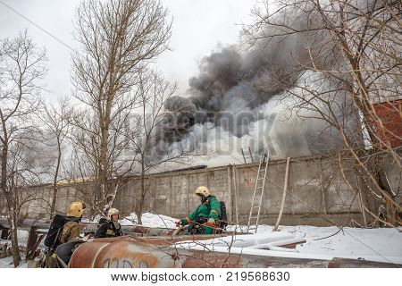 Voronezh, Russia - December 25: Fire in an industrial warehouse on Lantenskaya Street, rubber is burning, lots of smoke and flames, firefighters and MES rescue workers are struggling with a fire